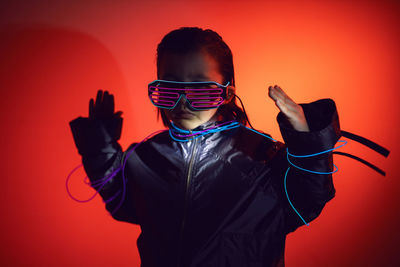 Portrait of a robot boy child from the future in neon glasses and jacket at night