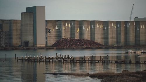 Reflection of building in sea against sky