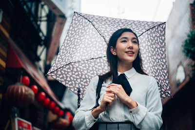 Young woman smiling while standing in rain