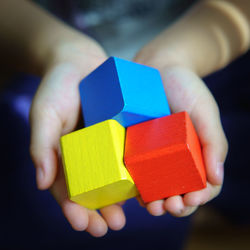 Close-up of hand holding multi colored blocks