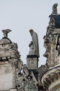 Low angle view of statue against building against clear sky