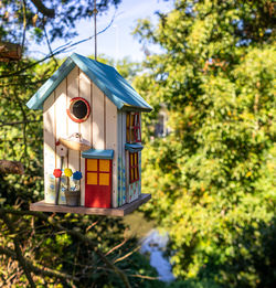 Low angle view of birdhouse on tree against building