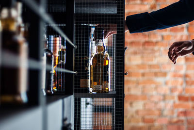 Cropped image of man buying whiskey from store