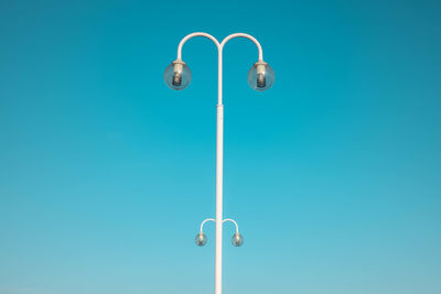 Close-up of street light against blue sky