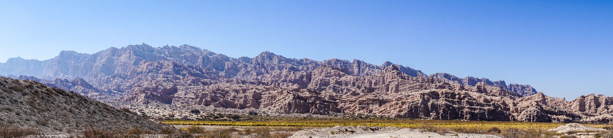 Panoramic view of landscape and mountains against clear blue sky