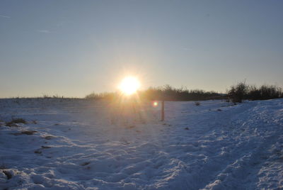 Sun shining over snow covered landscape