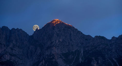 Mountain lit with torches at moonrise