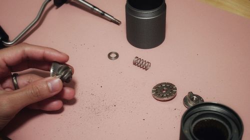 Cropped hand of person cleaning a coffee grinder on a table