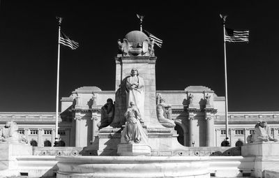 Low angle view of statue against building at night