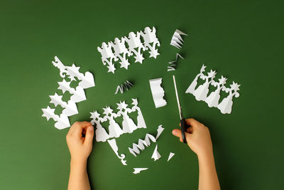 Low section of person holding paper against white background