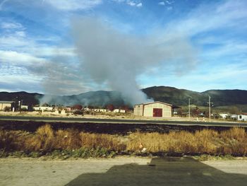 Smoke emitting from chimney against sky