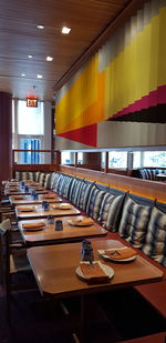 Empty chairs and tables in illuminated room