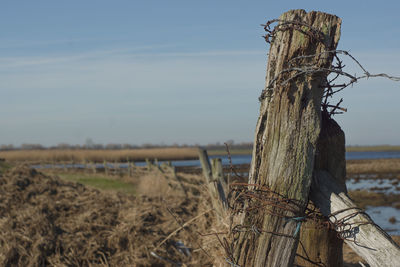 Wooden fence on field against sky