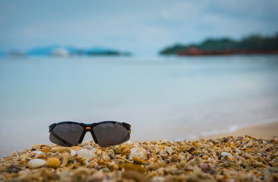 Close-up of sunglasses on beach