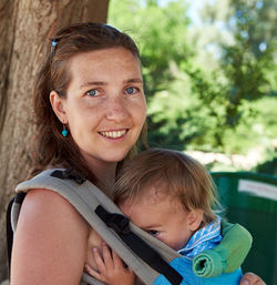 Close-up portrait of woman carrying son in baby carriage