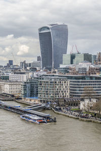 Modern buildings in city against cloudy sky