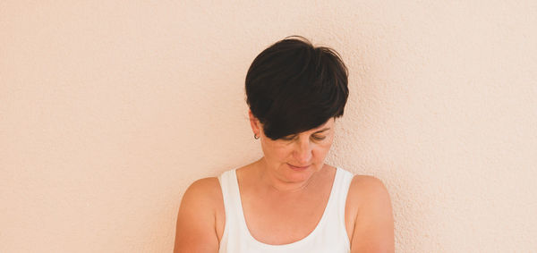 Side view of woman standing against wall