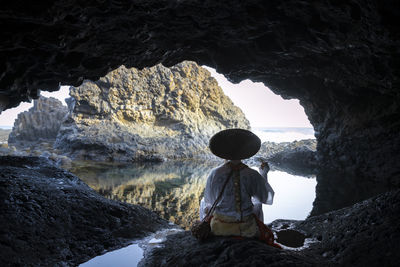 Rear view of man standing in cave