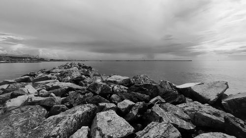 Rocks by sea against sky
