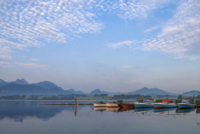 Boats moored in lake against sky