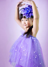 Portrait of cute girl standing against pink background