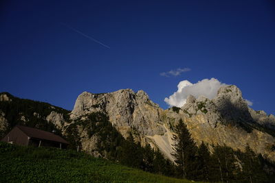 Low angle view of cottage against mountain range
