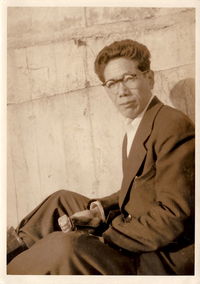 Young man sitting against wall