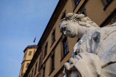 Low angle view of statue against building against sky