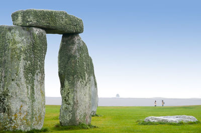 Stone wall on field against clear sky