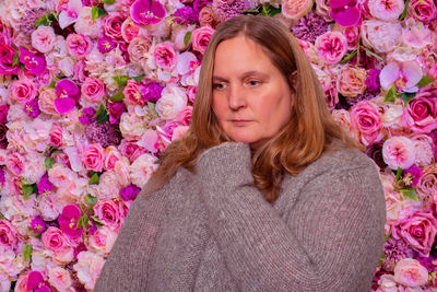 Model in a cardigan against a rose background