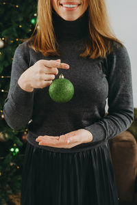 Midsection of woman standing against plants