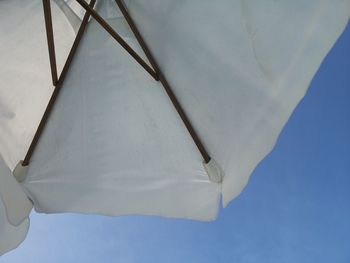 Low angle view of white umbrella against clear blue sky