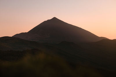 Scenic view of mountains against clear sky during sunset