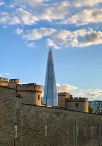 The shard emerging from the walls of the tower of london.