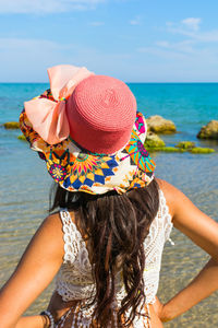 Rear view of woman in hat against sea