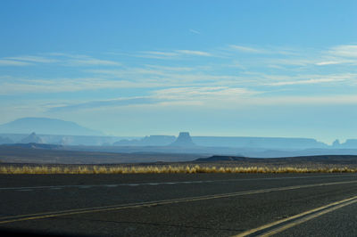 Road leading towards mountains against sky