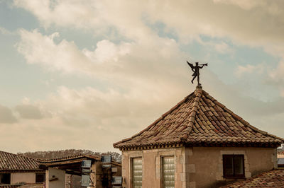 Low angle view of weather vane against sky