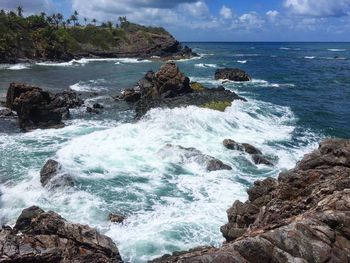 Scenic view of rocks on beach against sky