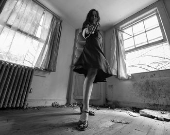 Full length of woman standing in abandoned building