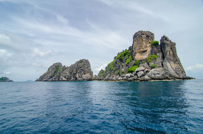 Rock formation in sea against sky