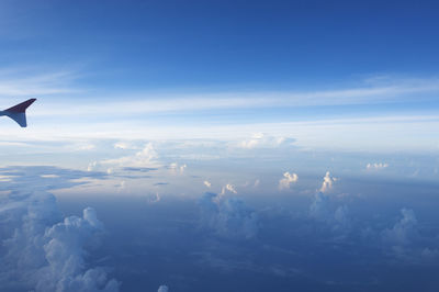 Airplane flying over sea against blue sky