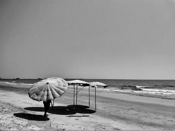 People on beach against clear sky