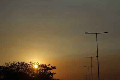 Low angle view of trees against sky at sunset