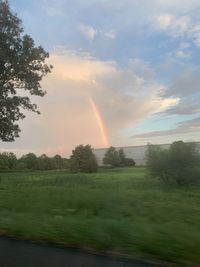 Scenic view of field against rainbow in sky