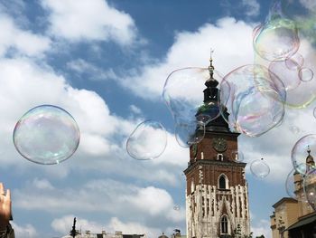 Low angle view of bubbles and buildings against sky