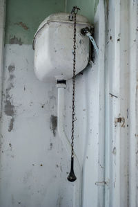 Close-up of rusty metal chain against wall