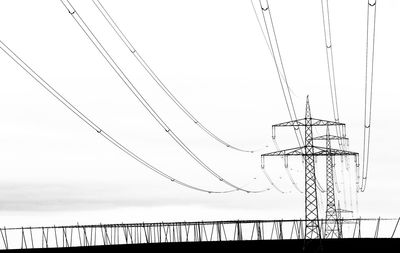 Low angle view of electricity pylon against sky