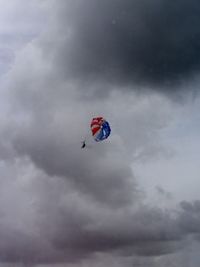 Low angle view of person paragliding against sky