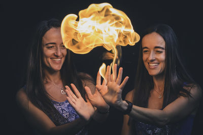 Sisters holding flames and fire in their hands