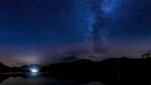 Scenic view of silhouette mountains against sky at night